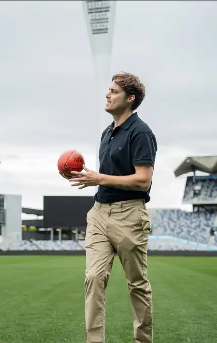 Kade on a football ground holding a ball